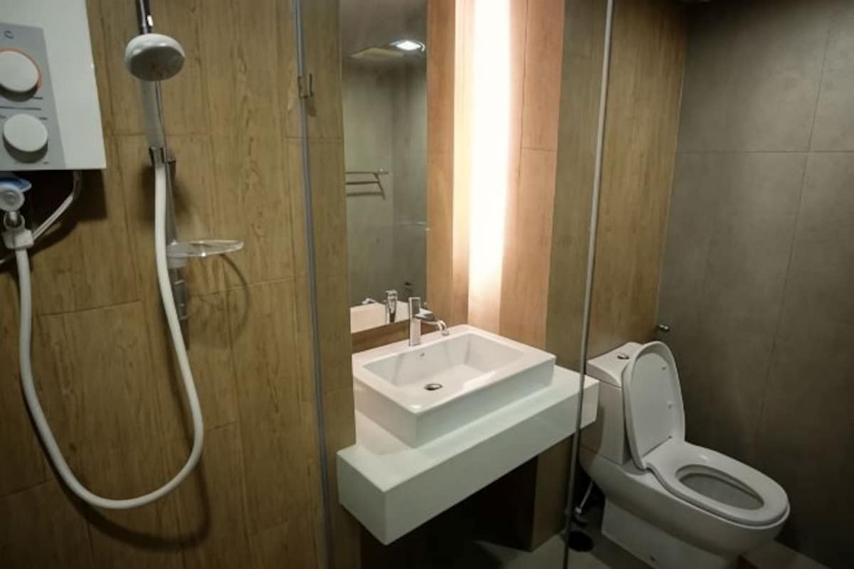 A bathroom with a white sink, a toilet, and a shower.