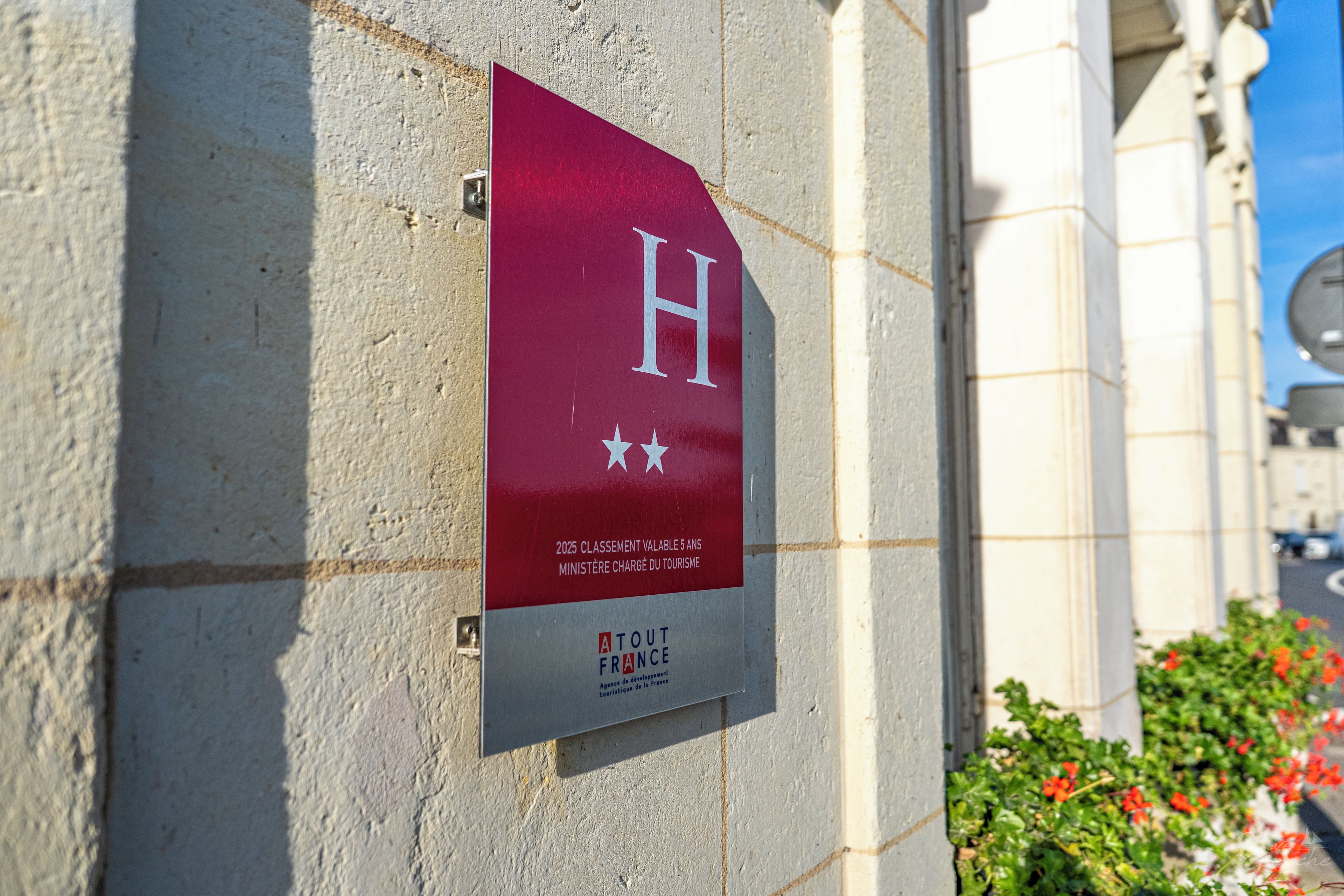 Un letrero con una 'H' grande en la pared de un edificio, que indica un hotel.