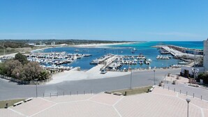 A marina with boats docked, a clear blue sky, and a beach in the background. - Nauticus Hotel Ugento (Ugento)