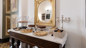 Una mesa de buffet con diversos postres y un espejo encima.