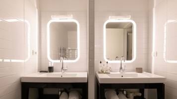 A modern bathroom with two sinks, each with a mirror and under-cabinet storage.