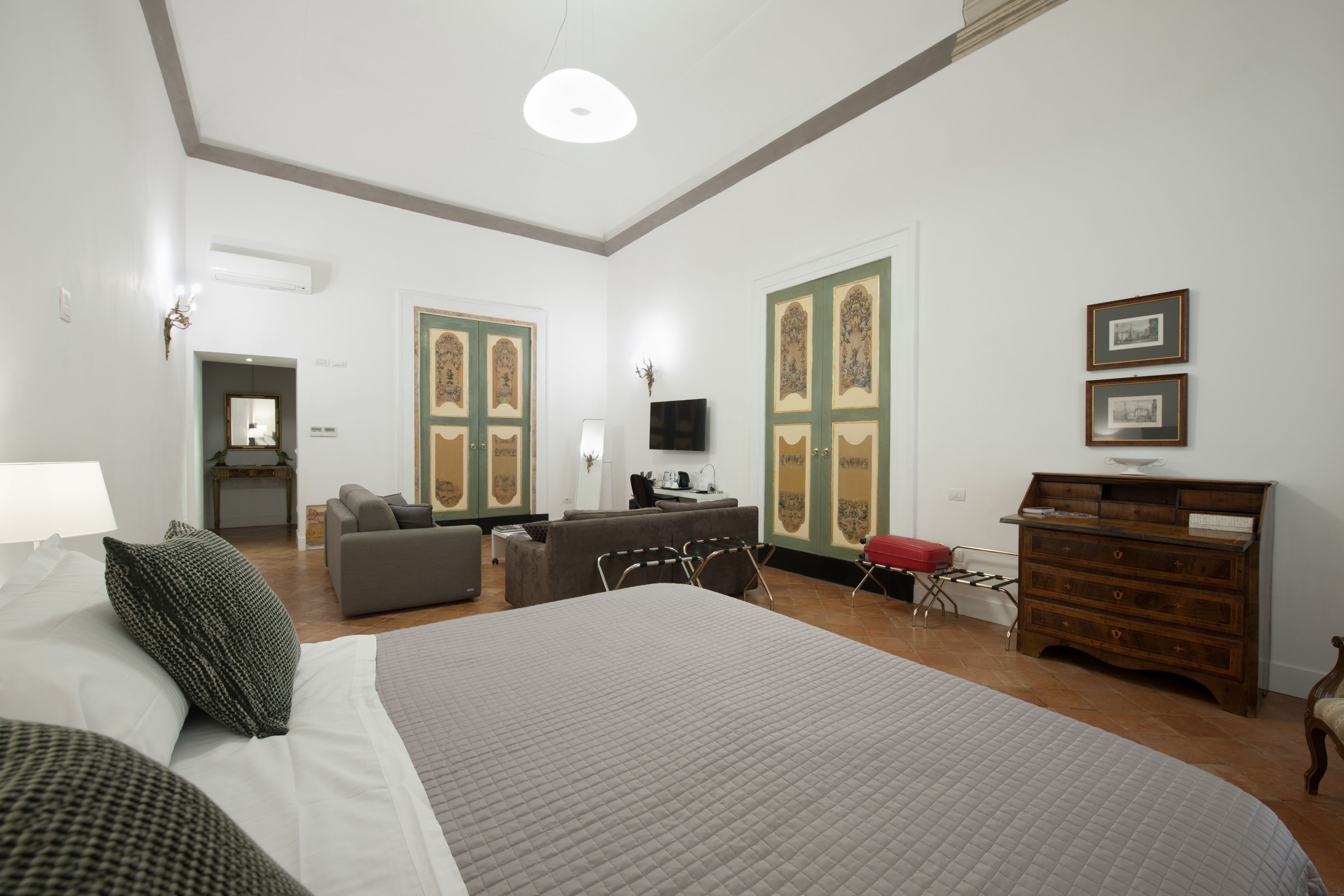 Una camera d'albergo con un letto grande, un divano, una scrivania e un comò.