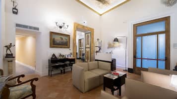 Un soggiorno spazioso con un divano color beige, un tavolino in legno e un'area pranzo con tavolo e sedie.