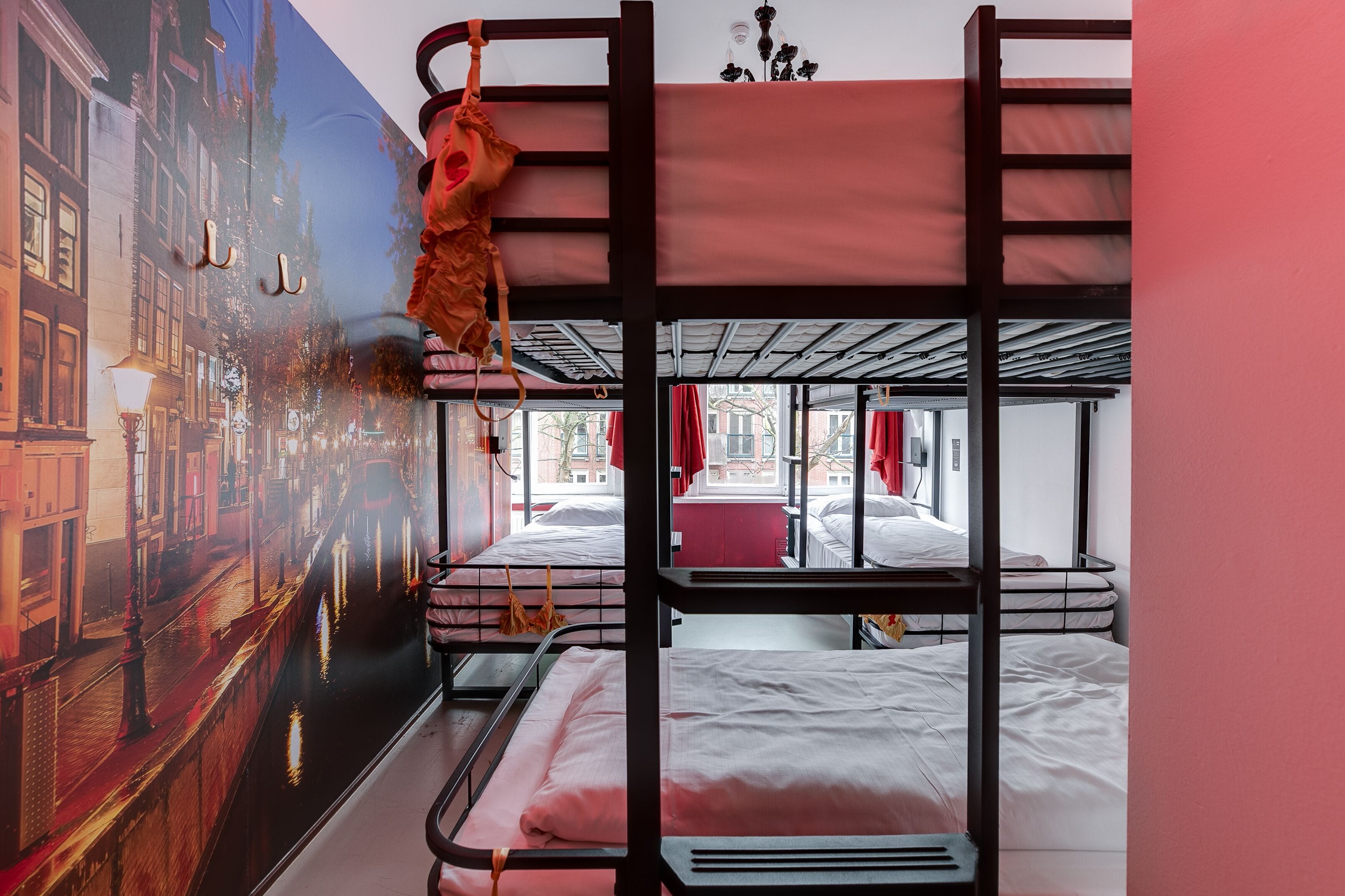 Een slaapkamer met een stapelbed en een stadsgezicht op de muur.