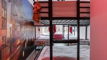 Een slaapkamer met een stapelbed en een stadsgezicht op de muur.