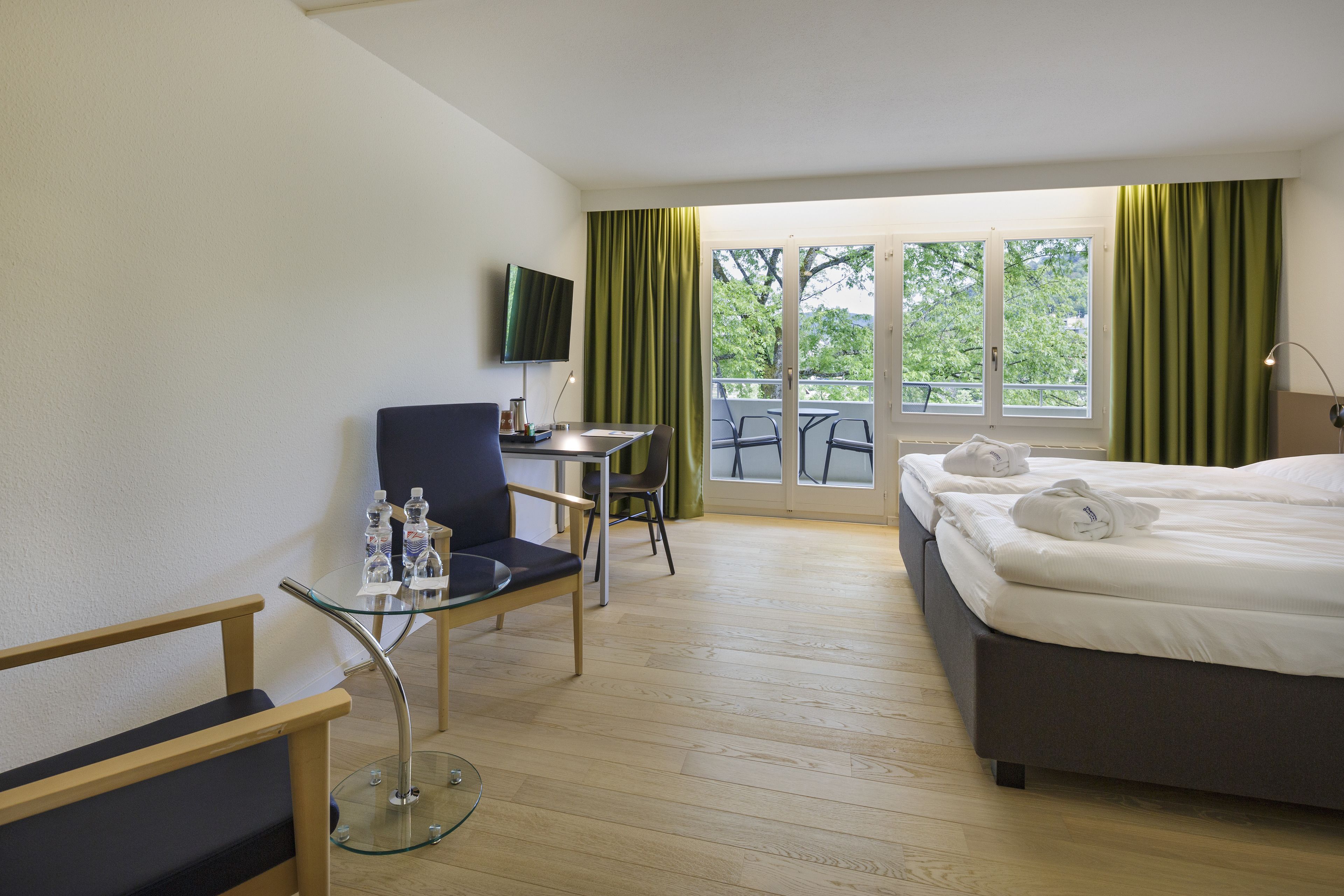 Een hotelkamer met een bed, bureau, stoel en televisie.