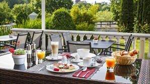 An outdoor dining area with tables, chairs, and a variety of breakfast items including eggs, toast, and pastries. - VitalBoutique Hotel Zurzacherhof (Bad Zurzach)