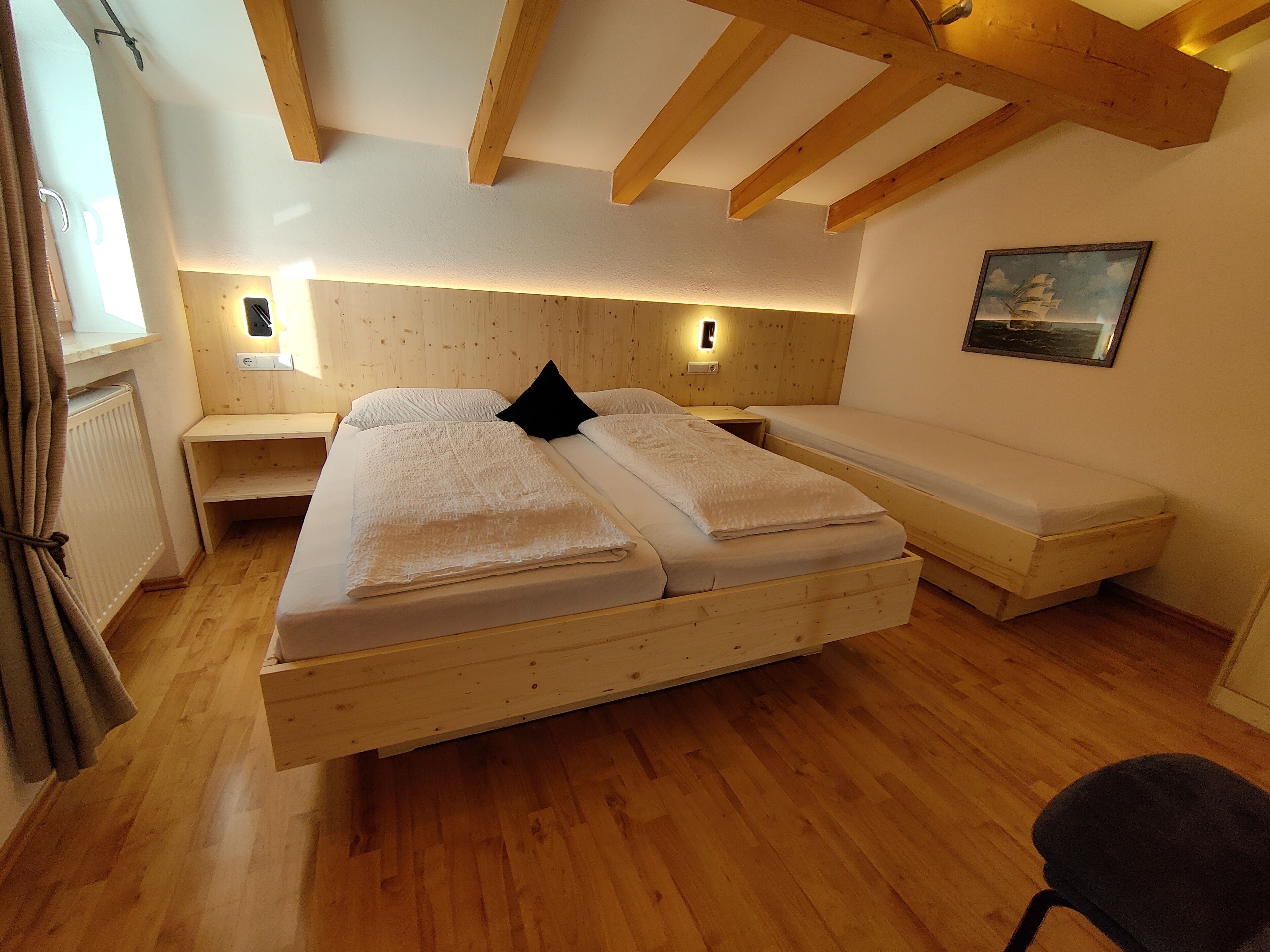 Ein gemütliches Zimmer mit einem großen Bett, einer Bank und einem Schreibtisch.