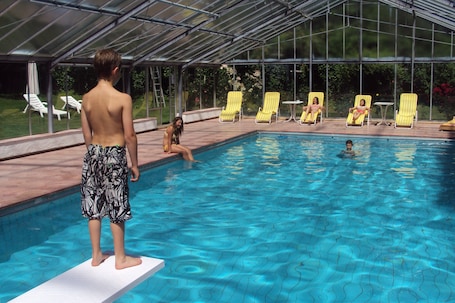 Una piscina al aire libre de temporada, sillones reclinables de piscina