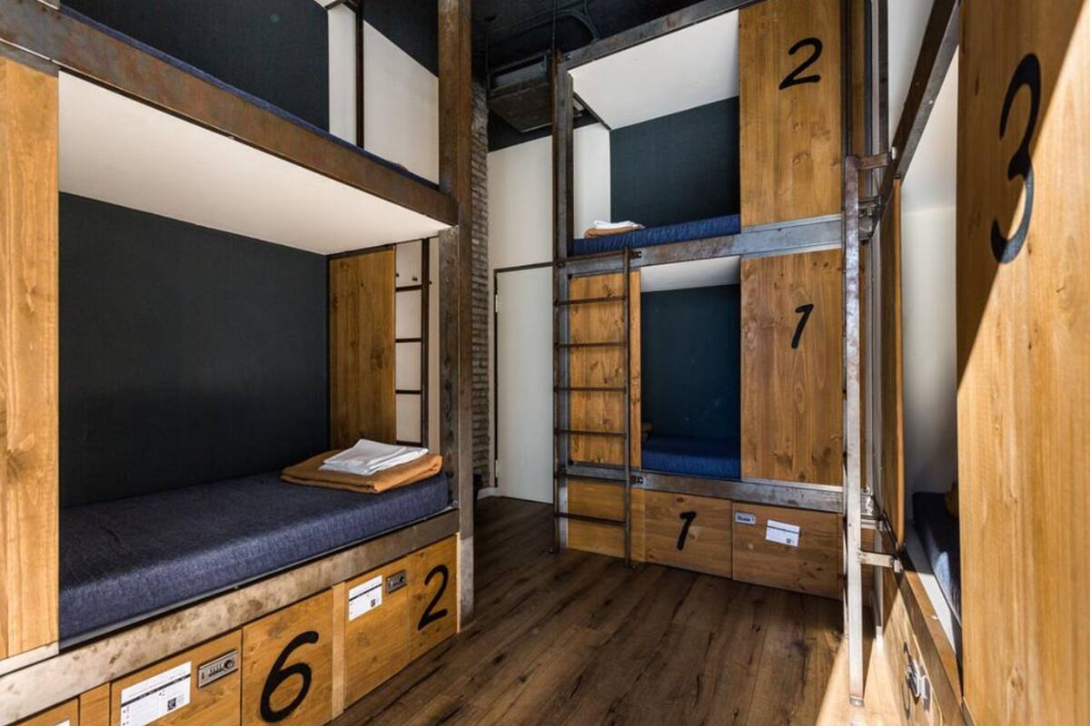 Habitación con literas, paredes de madera y compartimentos numerados.