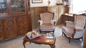 A traditional living room with wooden furniture, a glass-top coffee table, and a lamp. - Hotel Manitoba (Blankenberge)