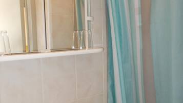 A bathroom with a white sink, a mirror, and a shower curtain.