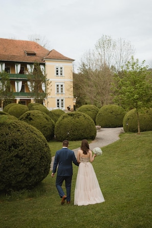 A couple walking on a grassy path with a building in the background. - Zabola Estate - Transylvania (Zabala)