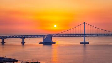 A bridge with a central island and a sunset in the background.