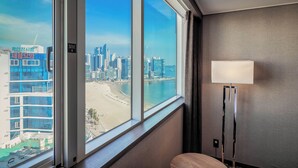 A hotel room with a large window offering a view of a beach and cityscape. - Kent Hotel Gwangalli by Kensington (Busan)