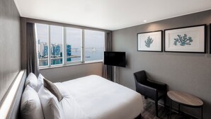 A hotel room with a large bed, a desk, a chair, and a TV. - Kent Hotel Gwangalli by Kensington (Busan)
