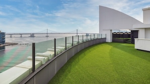 A modern building with a curved balcony overlooking a river and a bridge. - Kent Hotel Gwangalli by Kensington (Busan)