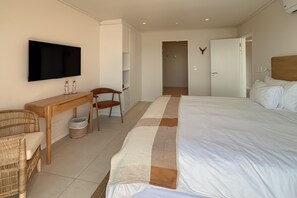 A hotel room with a bed, a desk, a chair, a television, and a wardrobe. - Finchley Guest House (Cape Town)