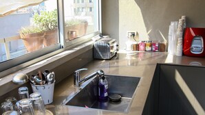 Une cuisine équipée d’un évier en acier inoxydable, d’un grille-pain et de divers ustensiles de cuisine.