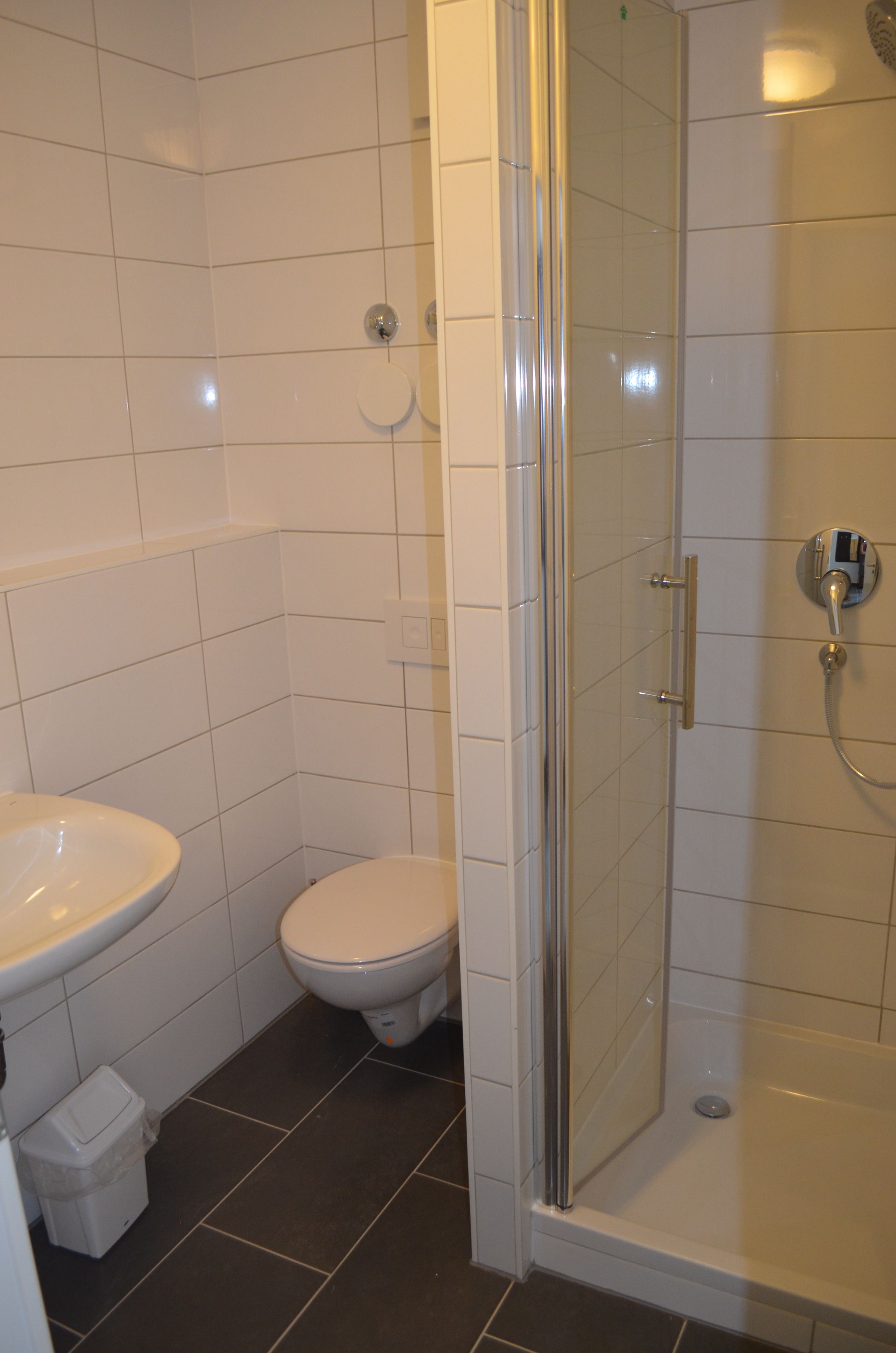 A bathroom with a toilet, sink, and shower.