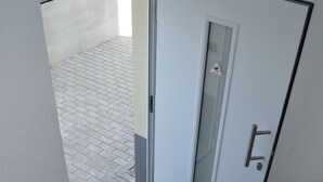 A staircase with a wooden handrail leading to a door with a glass panel. - Zwei Raben Pension (Mainz)