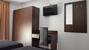 A hotel room with a bed, a desk, a chair, a TV, and a wardrobe. - Zwei Raben Pension (Mainz)