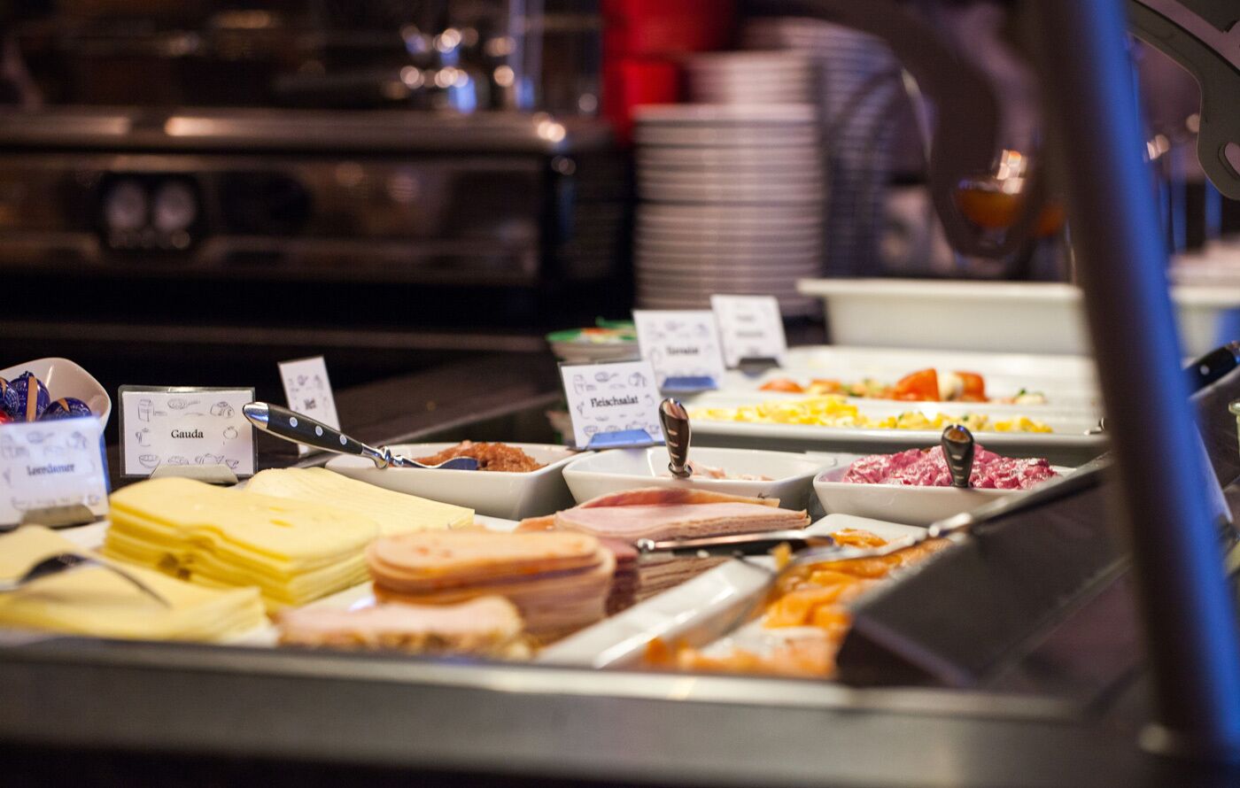 A buffet with various food items and utensils.