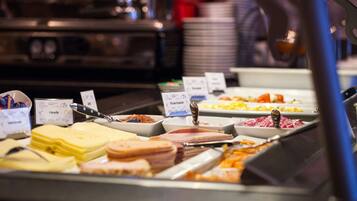 A buffet with various food items and utensils.