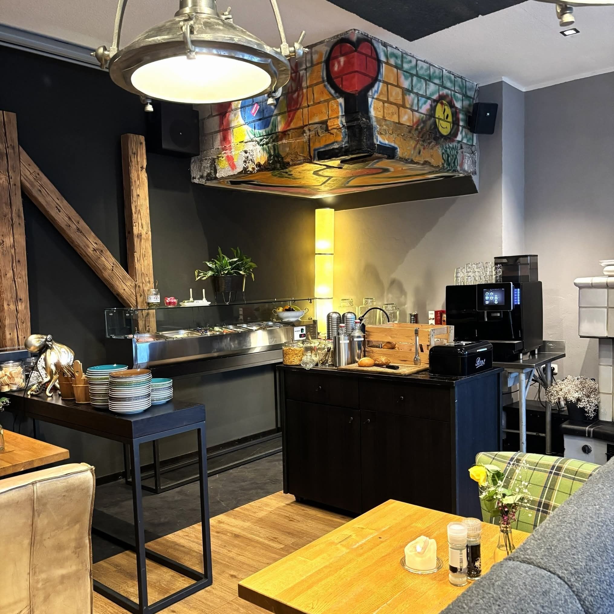 A modern kitchen with a central island, bar stools, and a coffee machine.