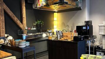 A modern kitchen with a central island, bar stools, and a coffee machine.