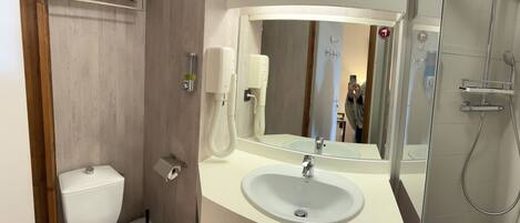 A modern bathroom with a toilet, sink, and shower.