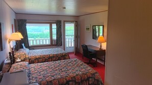 A hotel room with two beds, a desk, and a chair. There is a window with a view of greenery outside. - Singing Sands Inn Motel (Kingsboro)