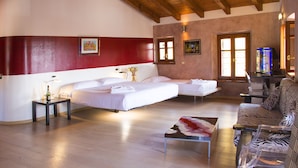 Une chambre d’hôtel avec un grand lit, un lit plus petit, un canapé et une table.