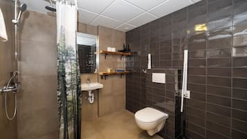 Un baño moderno con ducha, inodoro y lavamanos.