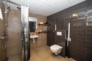 Un baño moderno con ducha, inodoro y lavamanos.