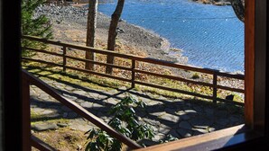 Vista de un lago con árboles y una valla de madera.