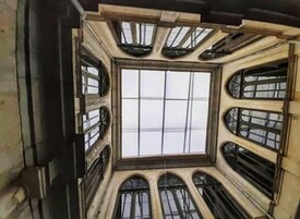 Una habitación con techo alto y abovedado, y varias ventanas.