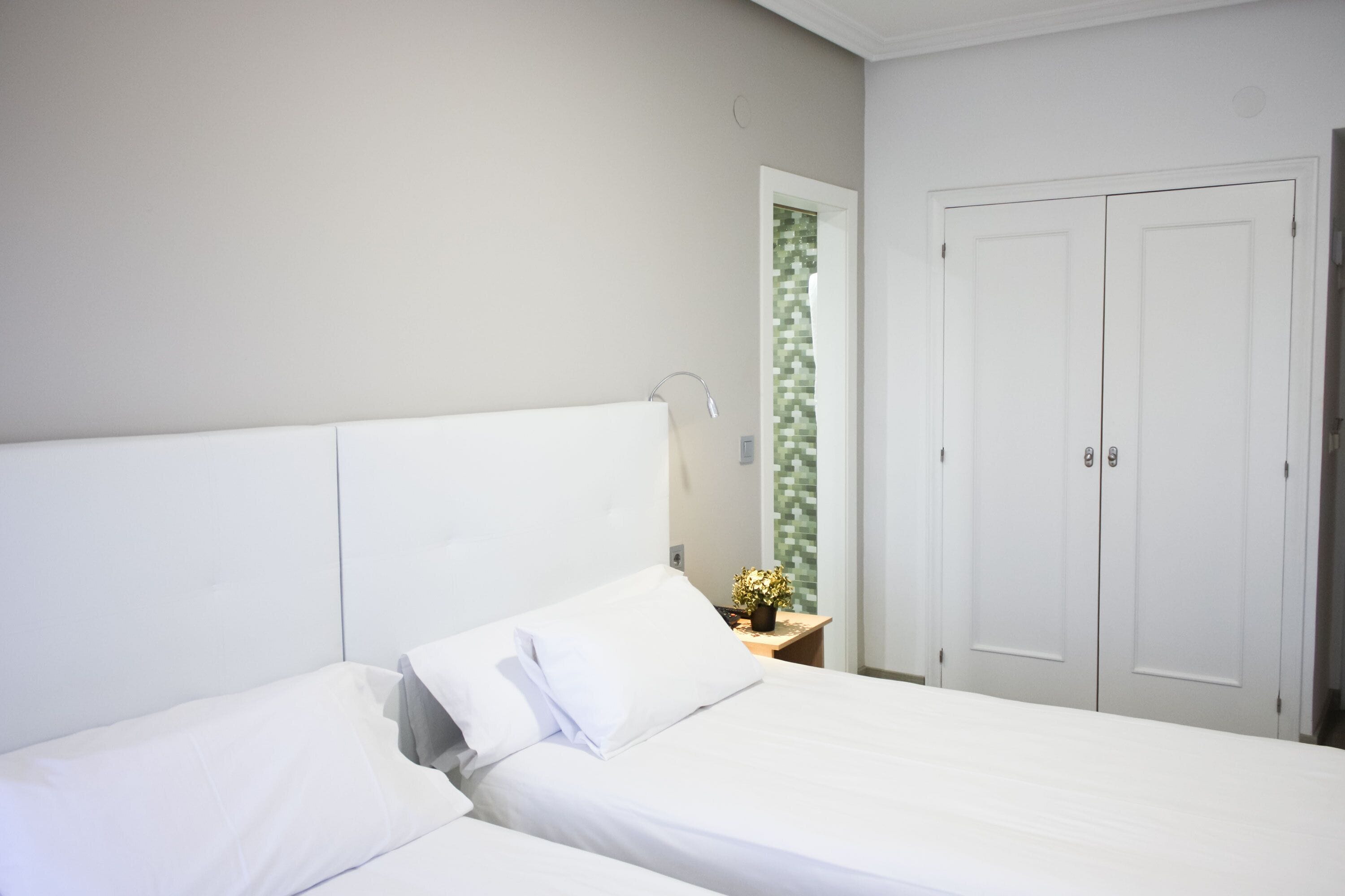 Un dormitorio con cama, mesita de noche, espejo y armario.