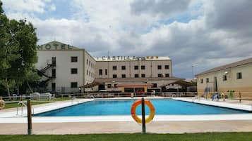 Una piscina al aire libre de temporada, sillones reclinables de piscina