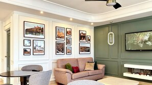A living room with a sofa, chairs, a coffee table, and framed pictures on the wall. - Hotel Castilla Torrijos (Torrijos)