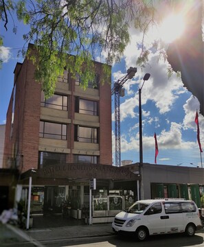 A hotel with a brick facade, large windows, and a sign indicating it is a hotel. - Hotel Ejecutivo Av Esperanza (Bogotá)