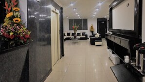 A modern lobby with a reception desk, seating area, and a large screen. - Hotel Ejecutivo Av Esperanza (Bogotá)
