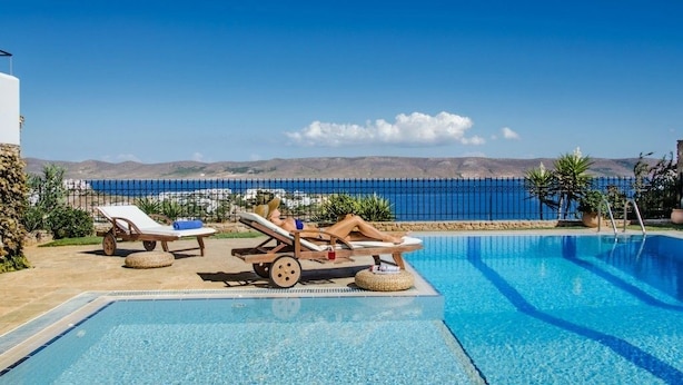 A pool area with lounge chairs and a view of the sea. - Sounio Villa (Lavreotiki)