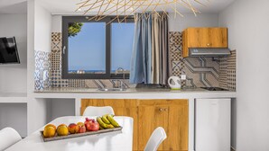 Una cocina moderna con un ventanal grande, un fregadero y un bol de frutas en la encimera.