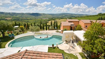 Una piscina al aire libre, sillones reclinables de piscina