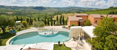 Una piscina al aire libre, sillones reclinables de piscina