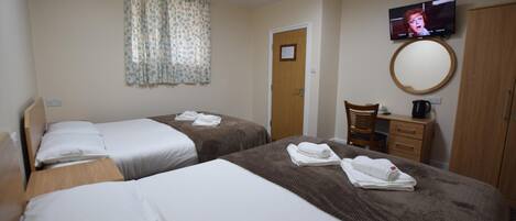 A hotel room with two beds, a television, a mirror, a wooden chair, and a desk.