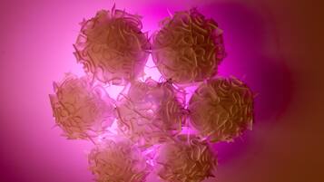 A geometric light fixture with a pinkish-purple background.