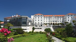 Un hotel grande de diseño moderno, con un patio central y jardines bien cuidados y una variedad de plantas.