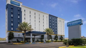 A City Express by Marriott hotel with a modern design, featuring a covered entrance and a parking lot. - City Express by Marriott New Orleans 1-10 (New Orleans)